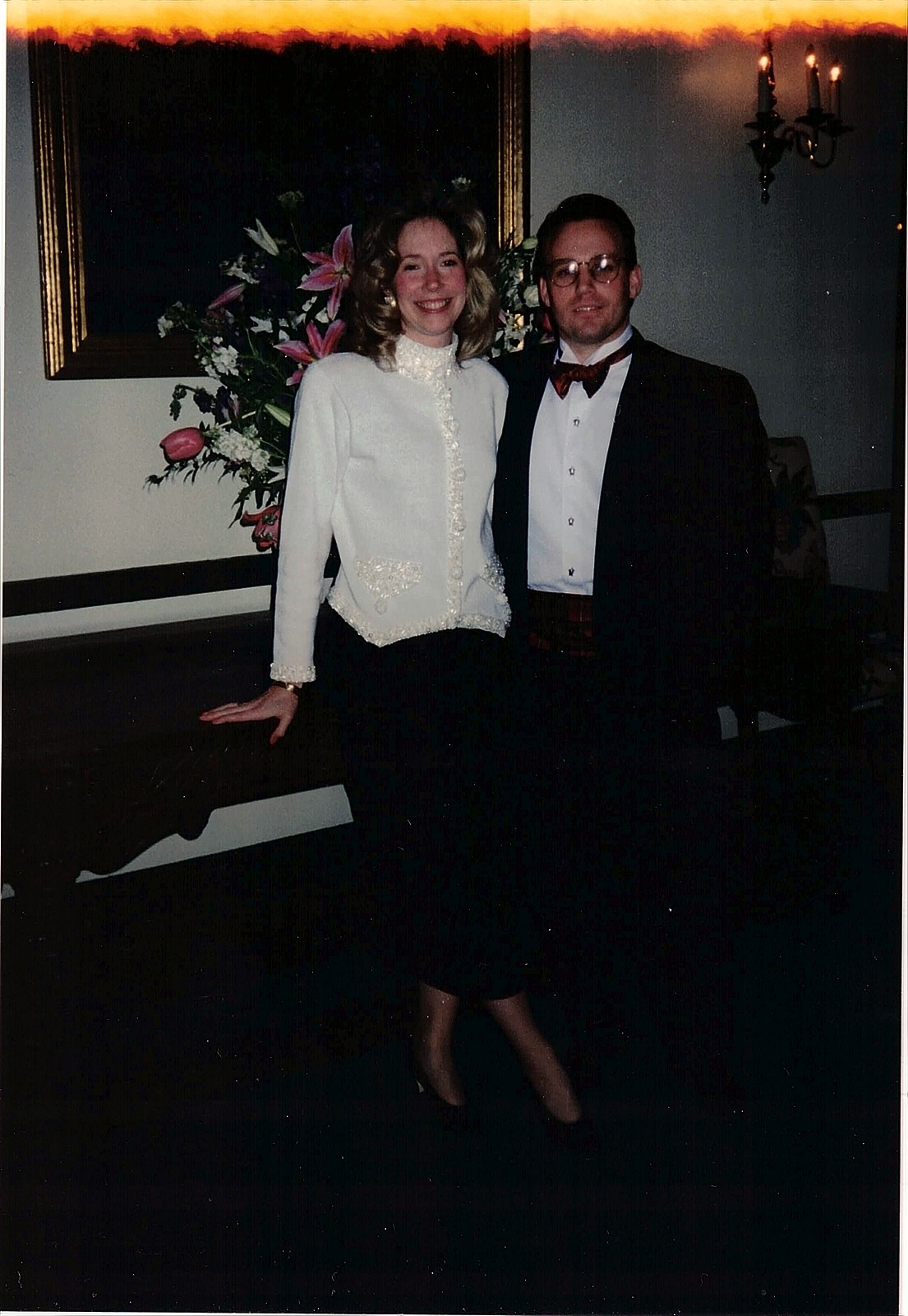 A wedding photograph of a young couple, the top of the frame burned by light